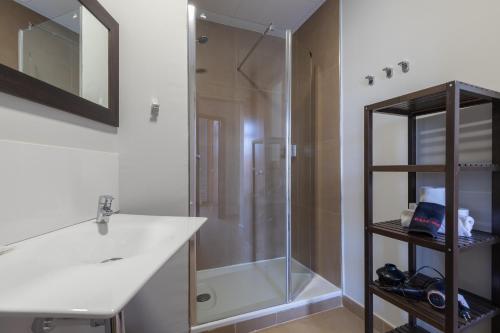 Un baño con ducha de cristal y lavabo. en Adarve Flats, en Valencia