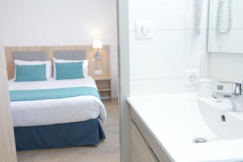 a hotel room with a bed and a sink at Boutique Hôtel d'Orbigny Chatelaillon - La Rochelle in Châtelaillon-Plage