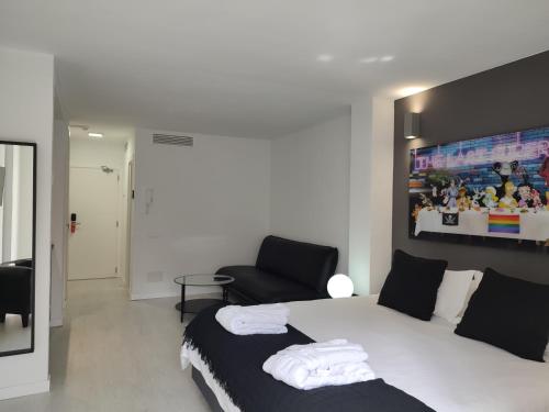 een slaapkamer met een wit bed en een stoel bij Urban Spaces Ibiza in Ibiza-stad