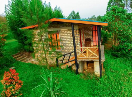 a small house in the middle of a field at Muga Eco Village in Ntungamo