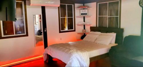 Ariami Rose في أغوادا: غرفة نوم مع سرير مع اللوح الأمامي الأخضر والنوافذ