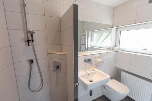 a bathroom with a sink and a toilet and a shower at Hotel Christine in Radolfzell am Bodensee