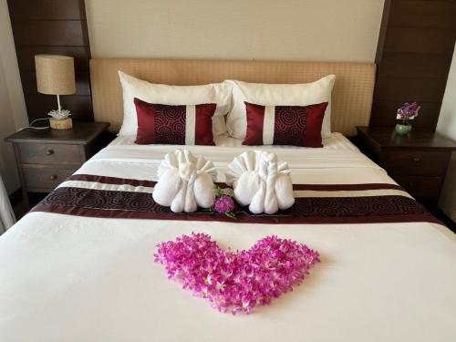 a bed with two towels and a heart on it at Panna Heritage Boutique Hotel - SHA Plus in Chiang Mai
