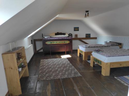 um quarto no sótão com 2 camas e um piano em Pensiunea Ramona em Viscri