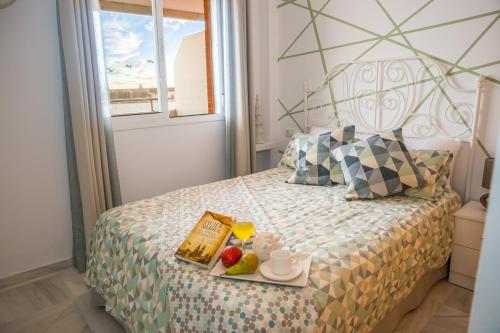 Un dormitorio con una cama con una bandeja de comida. en Casa Consorcio - Terraza en Barbate