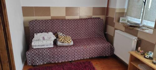 um sofá roxo com duas almofadas em Pensiunea Ramona em Viscri
