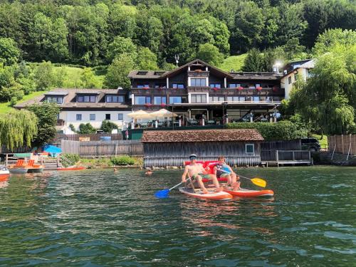 two people in a paddle boat on the water at Landhotel Grünberg am See in Gmunden