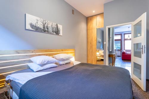 1 dormitorio con 1 cama con sábanas y almohadas azules en Apartamenty Łazarza 17, en Cracovia