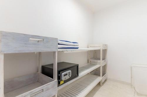 a bunk bed with a microwave on a shelf at Flamboyant Diani Beach in Diani Beach