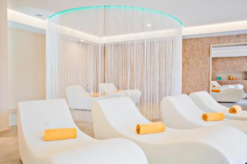 a waiting room with white chairs and a mirror at Hotel Sirmione Terme in Sirmione