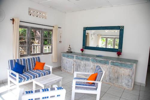 a living room with two chairs and a mirror at Flamboyant Diani Beach in Diani Beach