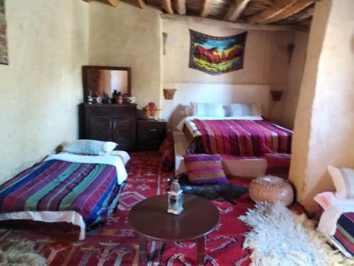 a room with two beds and a table in it at Maison d'hôte sirwaji in Assa