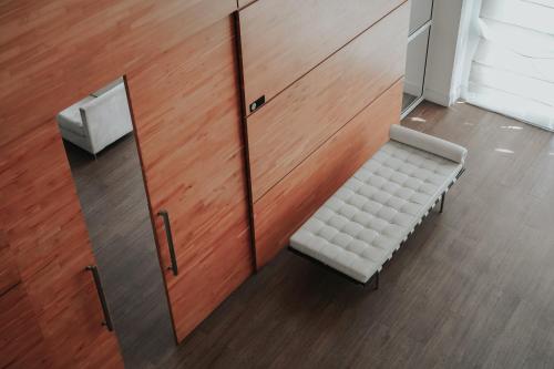 a white bench in a room with a wooden wall at Duplex NYC Berrini - 1506 in Sao Paulo