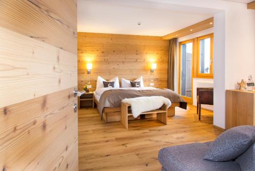 1 dormitorio con 1 cama y pared de madera en Hotel Bettmerhof en Bettmeralp
