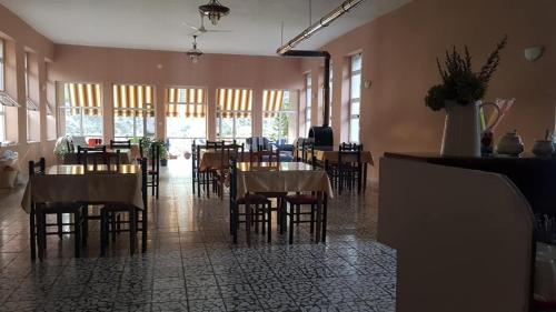 a restaurant with tables and chairs in a room at Agroturizem Hotel Vila Franceze in Koman