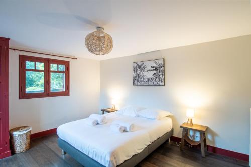 1 dormitorio con 1 cama con 2 toallas en VILLA BAÏTA - Maison avec jardin proche de la Dune du Pyla, en La Teste-de-Buch