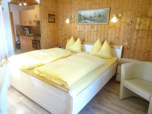 a bedroom with a large bed with yellow pillows at Badhaus in Achenkirch