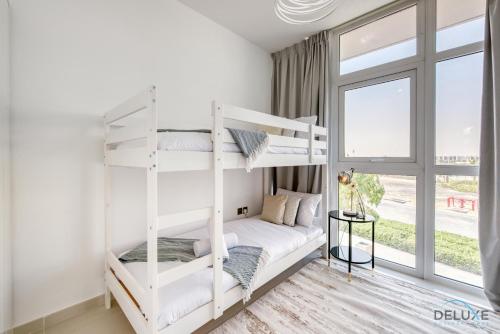 a bedroom with two bunk beds and a window at Affluent 3BR Townhouse at DAMAC Hills 2, Dubailand by Deluxe Holiday Homes in Dubai