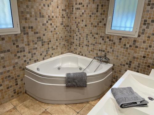 une baignoire blanche dans une salle de bain avec un lavabo dans l'établissement Villa avec piscine chauffée Nice collines, à Nice