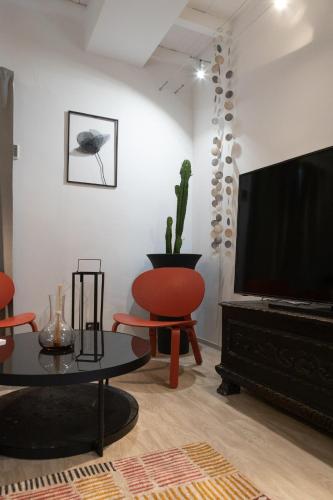 a living room with a flat screen tv and a table at Lo Schiaccianoci Bed&Breakfast de Charme in Scanzorosciate