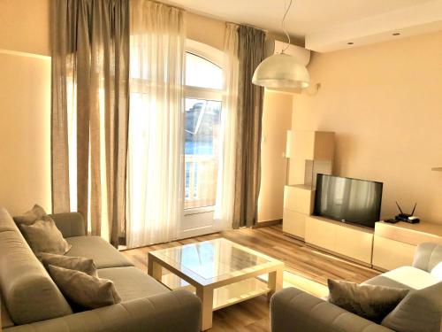 a living room with a couch and a tv at Lovely Apartment Sveti Stefan in Sveti Stefan