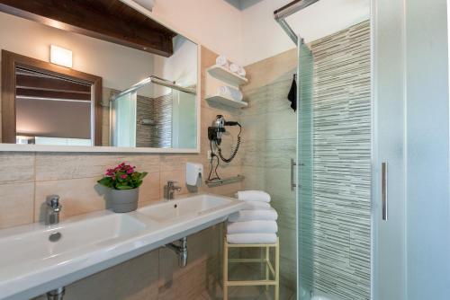 a bathroom with a sink and a glass shower at Vascellero Club Resort in Cariati