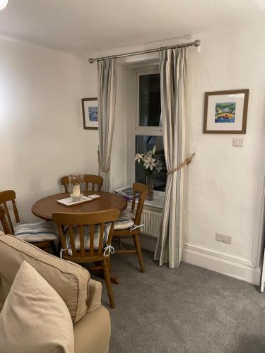 7 Mersey Street, Borth-y-Gest في بورثمادوج: غرفة معيشة مع طاولة وكراسي ونافذة