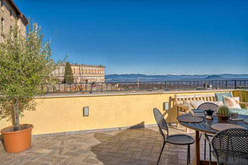 a patio with tables and chairs and a view of the ocean at Casa Checca e Casa Maria appartamenti per vacanze in Caprarola