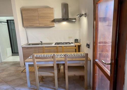 a kitchen with a table and chairs and a stove at CELESTE Central Apartment in Porto Rotondo with private parking in Porto Rotondo