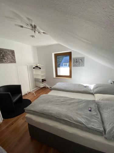 un dormitorio con una cama y una silla en Haus am Hang, en Bernkastel-Kues