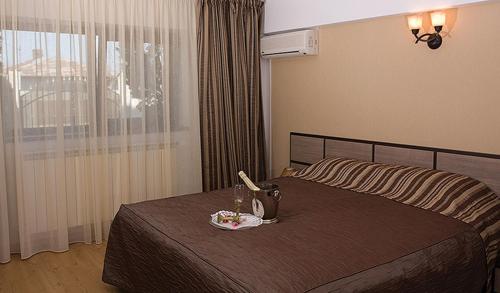 a hotel room with a bed with a plate of food on it at Vila Royal in Urziceni