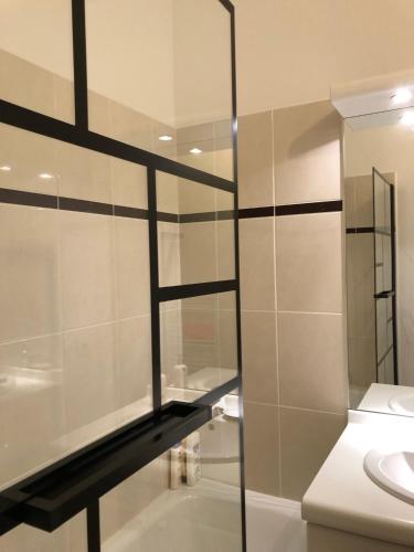 une salle de bain avec une douche en verre et un lavabo dans l'établissement Ideal flat Val d'Europe Disneyland with Parking, à Serris