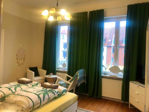 a bedroom with green curtains and a bed and a window at VILLA HanseART Lübeck - Privatzimmer in zentraler Lage in Lübeck