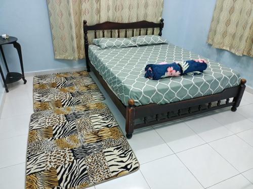two beds in a room with a doll laying on them at Ummi's Homestay Kuala Besut in Kampong Baru