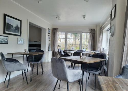 a dining room with tables and chairs and a window at Hotel-Pension Am Fuchsberg in Bad Doberan