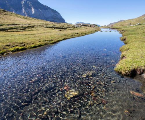 a river with rocks and a mountain in the background at L'Argalyde Esprit Pyrénées Wellness & Cycling in Ayzac-Ost