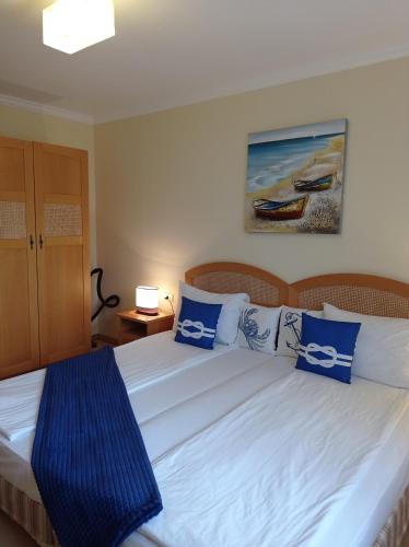 a bedroom with a bed with blue and white pillows at Lilia Sun Apartment in Sozopol