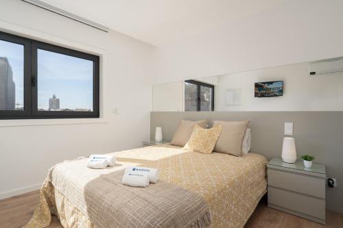a bedroom with a bed with two towels on it at Host Wise - Bright & Contemporary Flat - Ace Location in Porto