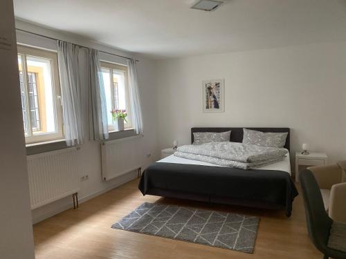 a bedroom with a bed and two windows and a rug at Altstadt Apartment in Bamberg