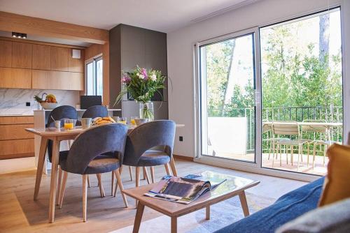 eine Küche und ein Wohnzimmer mit einem Tisch und Stühlen in der Unterkunft Magnifique Appartement Design Parking Chiberta in Anglet