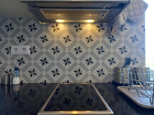 a kitchen with a sink and a tiled wall at Martins Apartment - Belch1952 in Lagos