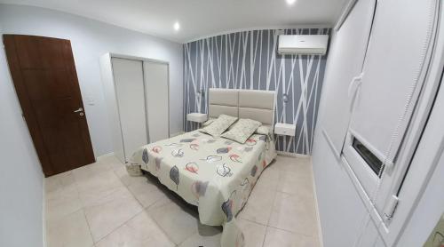a small bedroom with a bed and a door at Los 7 Deseos in Tandil