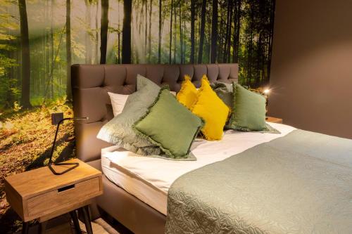 um quarto com uma cama com almofadas coloridas em Gite Au Coeur de Han em Han-sur-Lesse
