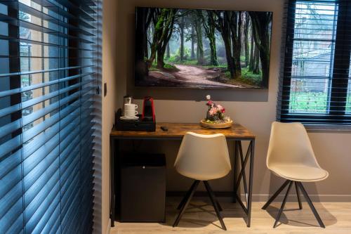 a table with two chairs and a painting on the wall at Gite Au Coeur de Han in Han-sur-Lesse