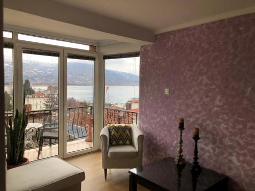 a living room with a couch and a table and windows at Villa Stefanija in Ohrid