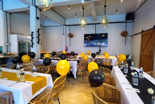 a room with tables with yellow balloons on them at A Coral Reefs Resort Langkawi in Kuah