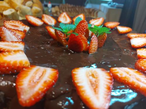 a chocolate cake with strawberries on top of it at Pousada Recanto da Montanha in Visconde De Maua