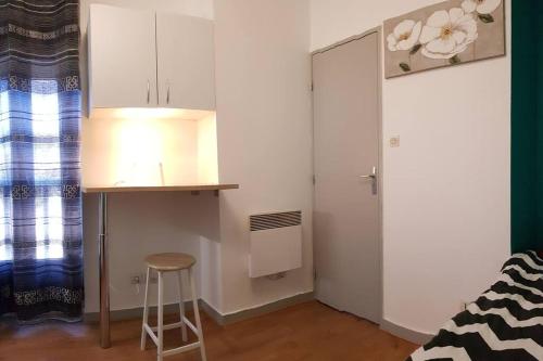 a small kitchen with a stool and a table in a room at Studio de 12m² agréable calme proche CHU in Dijon