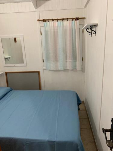 um quarto com uma cama azul e um espelho em Soggiorno paradisiaco in bungalow sulla spiaggia em Crotone