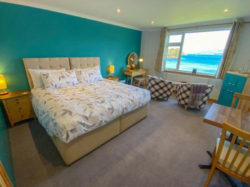 a bedroom with a bed and a blue wall at An-Airidh Bed & Breakfast Portree in Portree